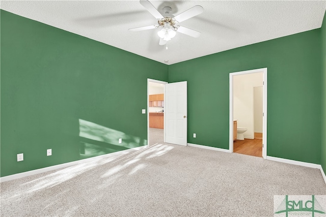 unfurnished bedroom featuring a textured ceiling, ceiling fan, light carpet, and ensuite bath