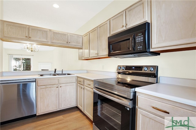 kitchen featuring a chandelier, light brown cabinetry, stainless steel appliances, and sink