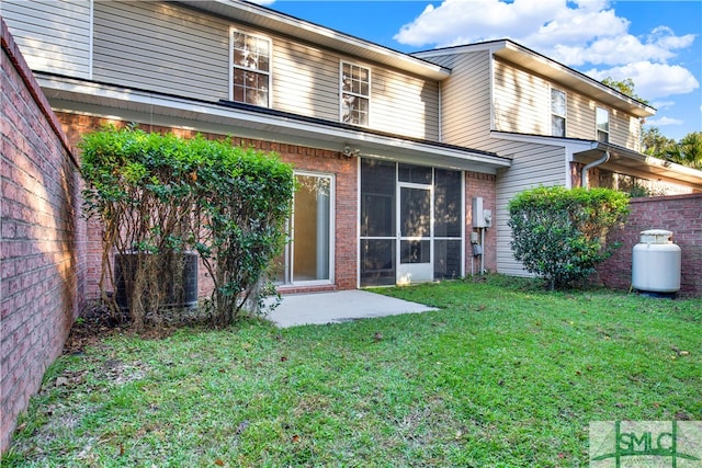 rear view of property with a yard and a patio