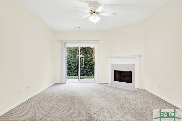 unfurnished living room featuring carpet flooring, ceiling fan, and a tiled fireplace