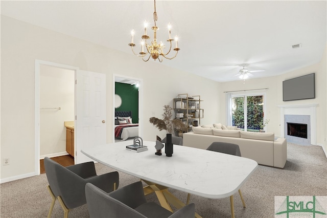 dining area with ceiling fan with notable chandelier and carpet floors