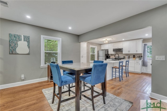 dining space featuring light hardwood / wood-style floors, a healthy amount of sunlight, and sink