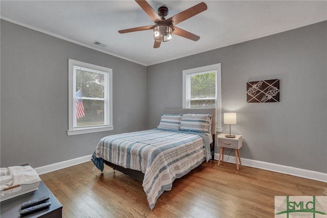 bedroom featuring light wood-type flooring, ceiling fan, and ornamental molding