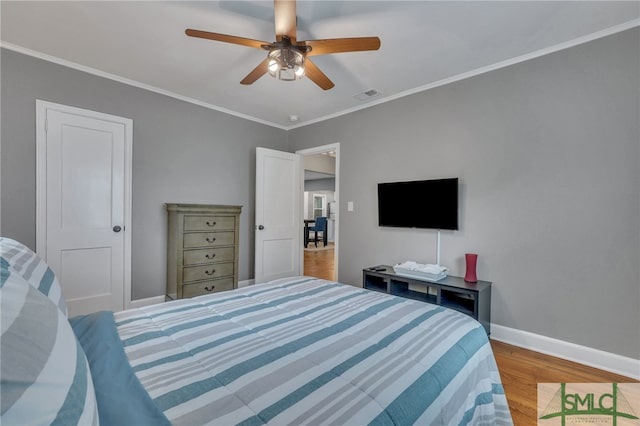 bedroom featuring ceiling fan, wood-type flooring, and ornamental molding