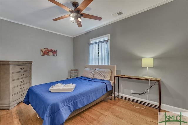 bedroom featuring hardwood / wood-style floors, ceiling fan, and crown molding