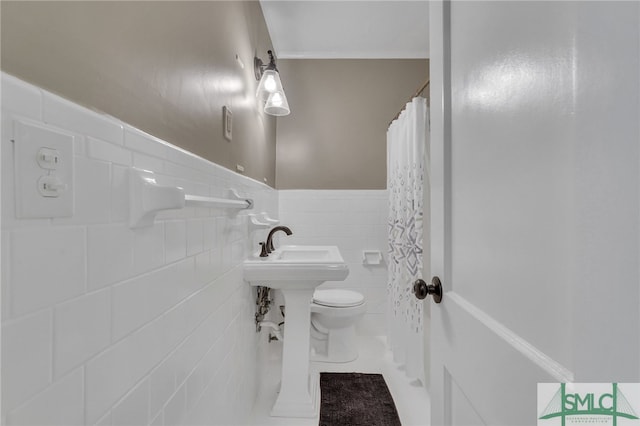 bathroom with tile patterned flooring, a shower with shower curtain, toilet, and tile walls