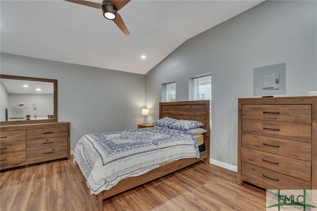 bedroom with ceiling fan, lofted ceiling, electric panel, and light hardwood / wood-style flooring