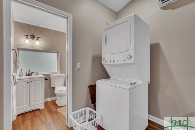 laundry room featuring stacked washing maching and dryer and wood-type flooring