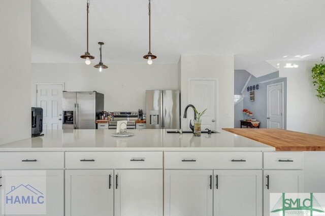 126 Thornbush Ct NE, Ludowici, GA 31316 - kitchen featuring stainless steel refrigerator with ice dispenser, white cabinetry, and hanging light fixtures