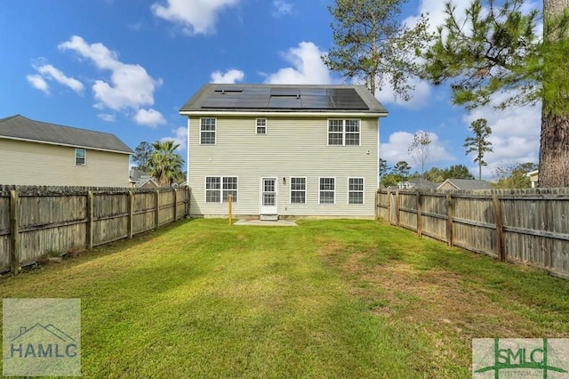 126 Thornbush Ct NE, Ludowici, GA 31316 - back of property featuring a lawn and solar panels
