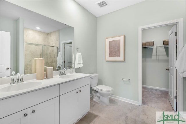 bathroom featuring toilet, a stall shower, visible vents, and a sink