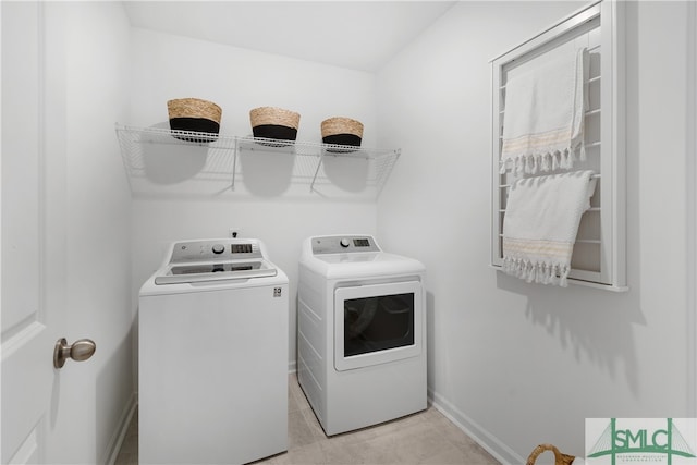 laundry area with laundry area, washing machine and clothes dryer, and baseboards