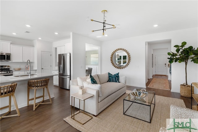 living area with recessed lighting, dark wood-style flooring, visible vents, and an inviting chandelier