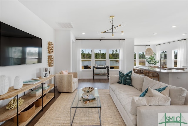 living area featuring an inviting chandelier, wood finished floors, visible vents, and recessed lighting