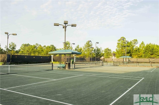 view of tennis court featuring fence