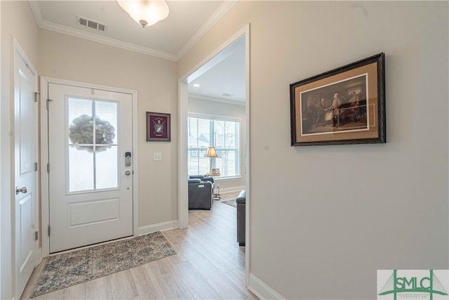 foyer with crown molding and light hardwood / wood-style flooring