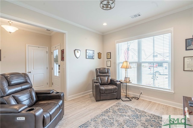 living area with ornamental molding, a wealth of natural light, and light hardwood / wood-style floors