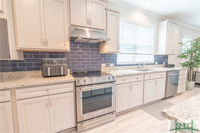 kitchen featuring sink, appliances with stainless steel finishes, backsplash, ornamental molding, and light stone countertops