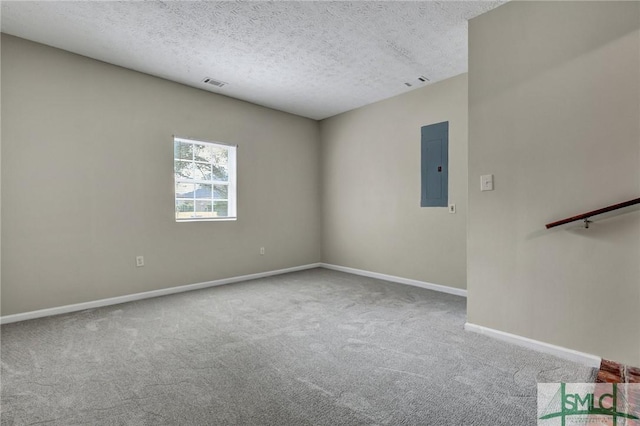 carpeted empty room with electric panel and a textured ceiling