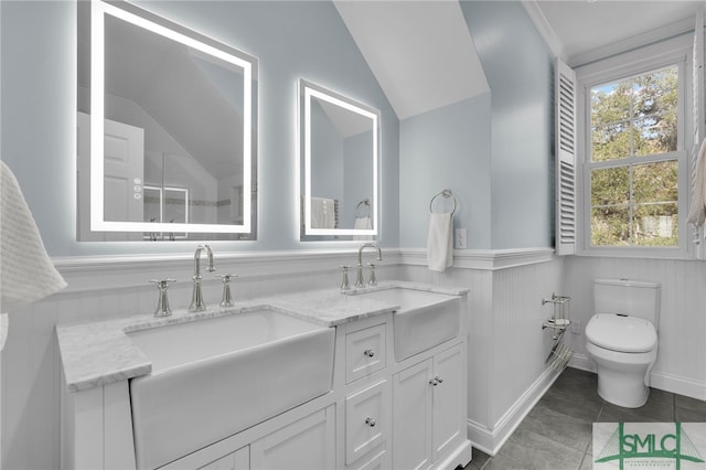 bathroom featuring tile patterned floors, vanity, toilet, and lofted ceiling