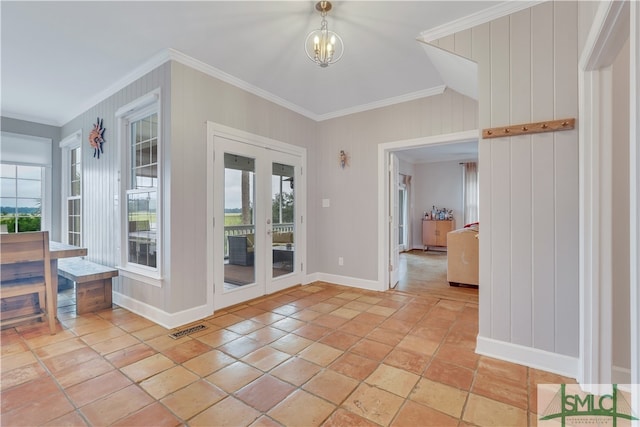 foyer featuring crown molding, plenty of natural light, a chandelier, and french doors