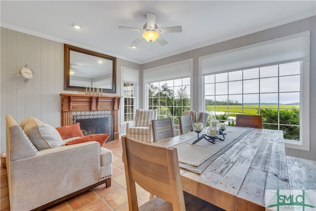 sunroom with a tile fireplace and ceiling fan