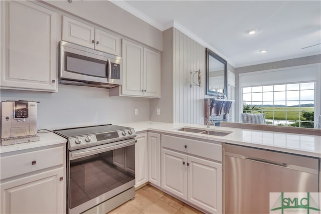 kitchen featuring white cabinetry, stainless steel appliances, and ornamental molding