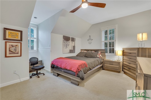 bedroom with ceiling fan, light colored carpet, and vaulted ceiling