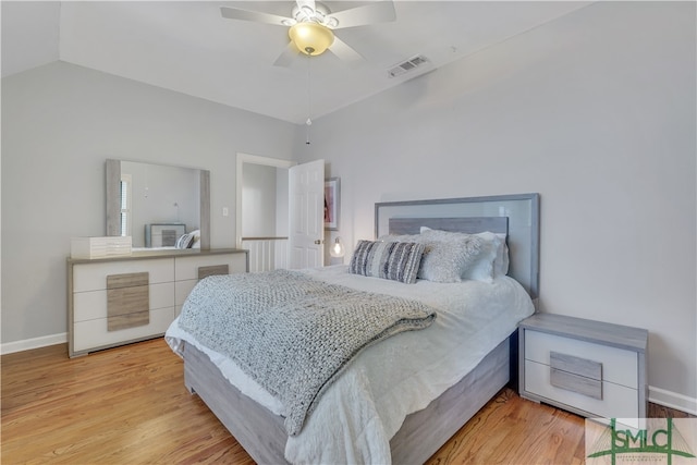 bedroom featuring light hardwood / wood-style floors, vaulted ceiling, and ceiling fan