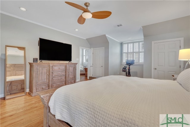 bedroom featuring ceiling fan, ensuite bath, crown molding, and light hardwood / wood-style flooring