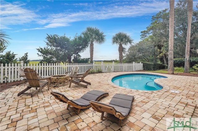 view of pool with a patio and a fire pit