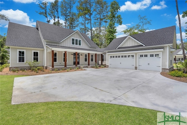 view of front of house with a garage, covered porch, and a front yard