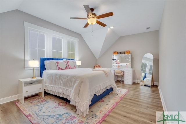 bedroom with ceiling fan, hardwood / wood-style floors, and vaulted ceiling