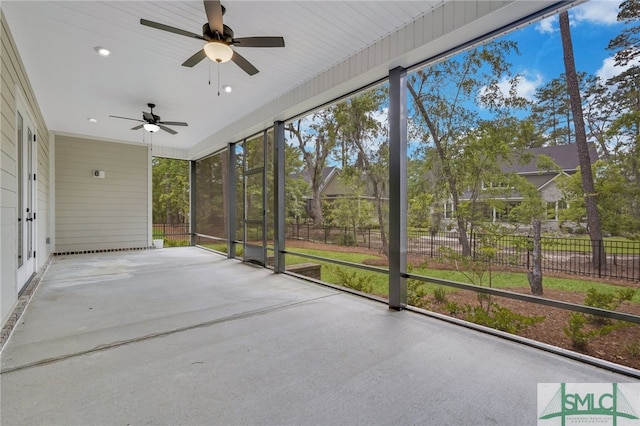 unfurnished sunroom with ceiling fan