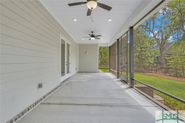 unfurnished sunroom with ceiling fan