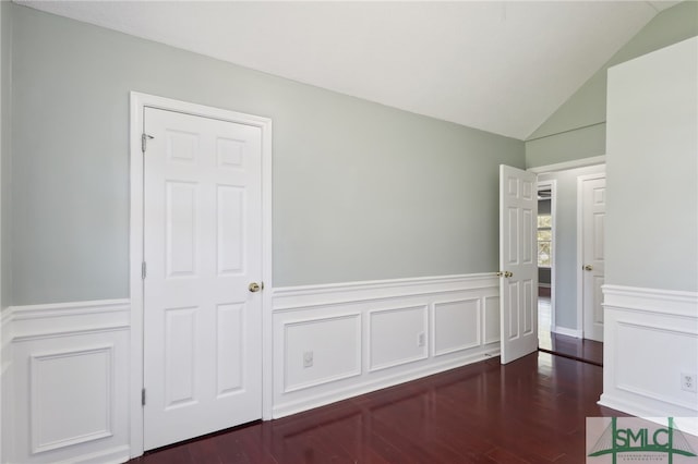 unfurnished room featuring dark hardwood / wood-style floors and lofted ceiling