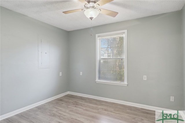 unfurnished room with ceiling fan, a textured ceiling, and light wood-type flooring