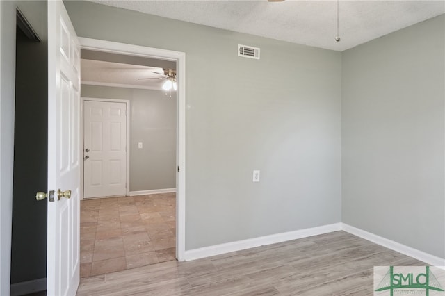 unfurnished room with ceiling fan, a textured ceiling, and light hardwood / wood-style flooring