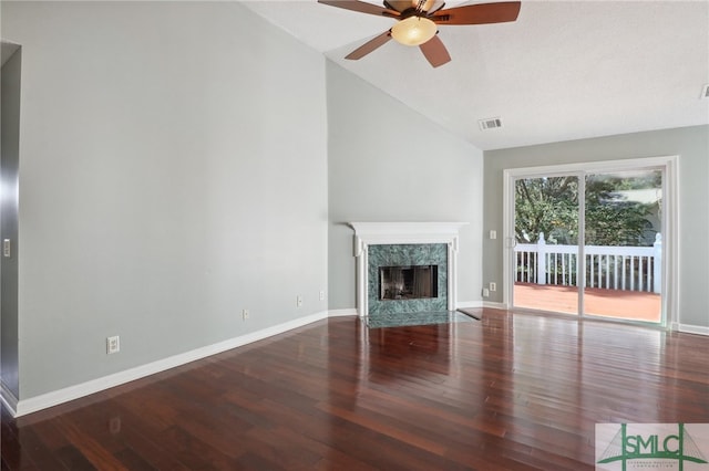 unfurnished living room with ceiling fan, a fireplace, vaulted ceiling, and hardwood / wood-style flooring