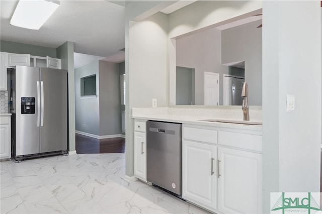 kitchen featuring white cabinets, stainless steel appliances, and sink