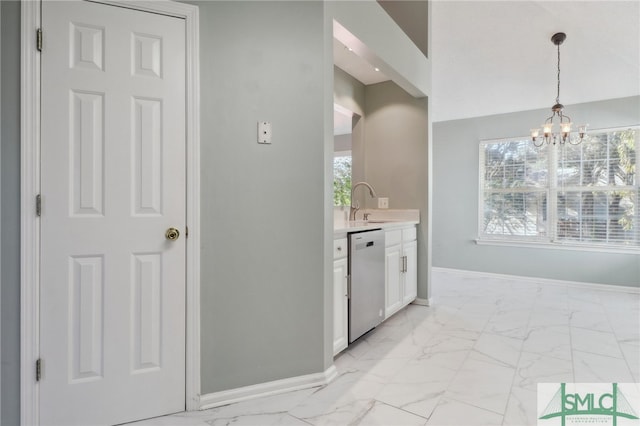 kitchen with stainless steel dishwasher, sink, a chandelier, white cabinetry, and hanging light fixtures