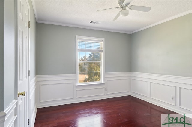 empty room with a textured ceiling, dark hardwood / wood-style flooring, ceiling fan, and crown molding