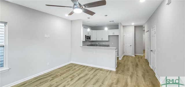 kitchen featuring sink, ceiling fan, white cabinetry, light hardwood / wood-style floors, and kitchen peninsula