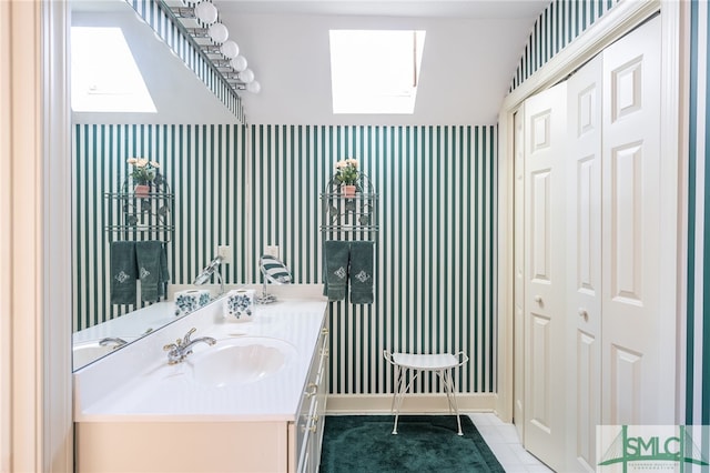 bathroom with tile patterned flooring, vanity, and a skylight