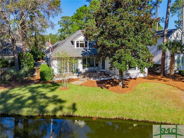 back of house featuring a lawn and a water view