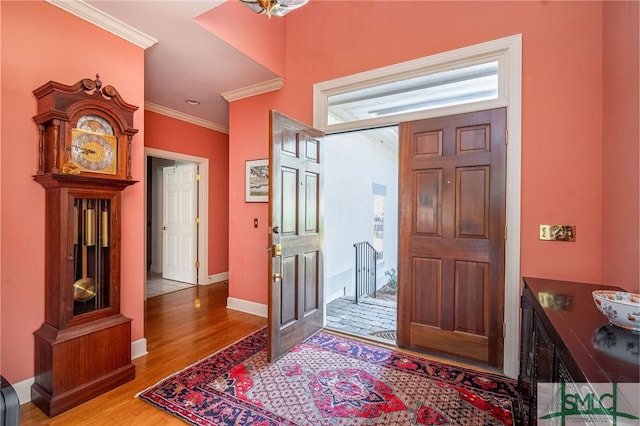 foyer with ornamental molding and light hardwood / wood-style floors