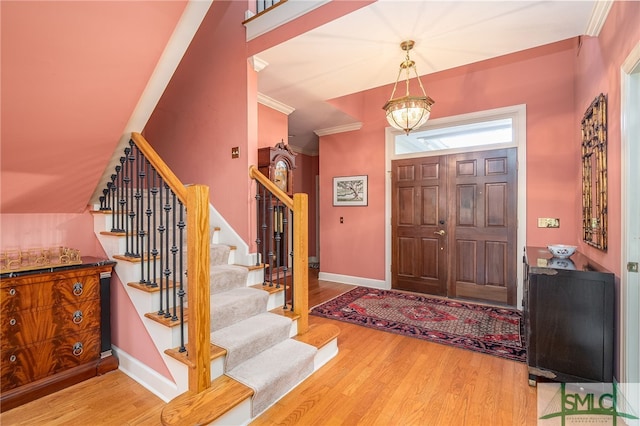 entrance foyer with crown molding and hardwood / wood-style floors