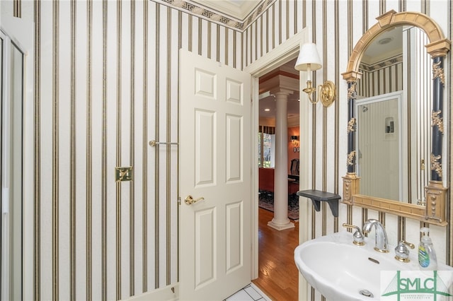 bathroom with ornate columns, wood-type flooring, and sink