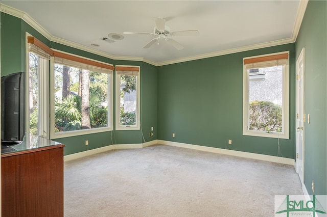 carpeted spare room featuring crown molding and ceiling fan