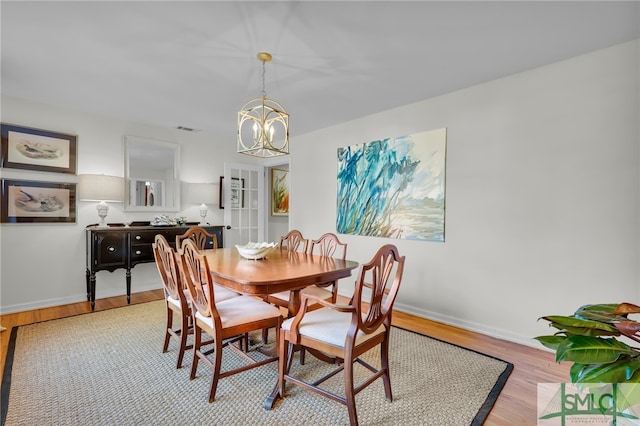 dining area featuring a chandelier and light hardwood / wood-style flooring